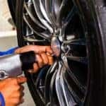 mechanic getting ready to take a tire off a car