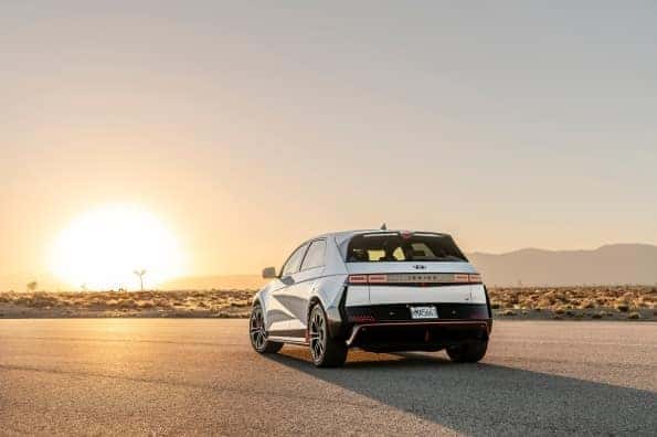 White Hyundai IONIQ 5 parked with a sunset