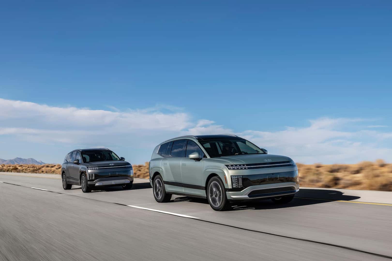 A grey and a green 2026 IONIQ 9 vehicles on a highway road