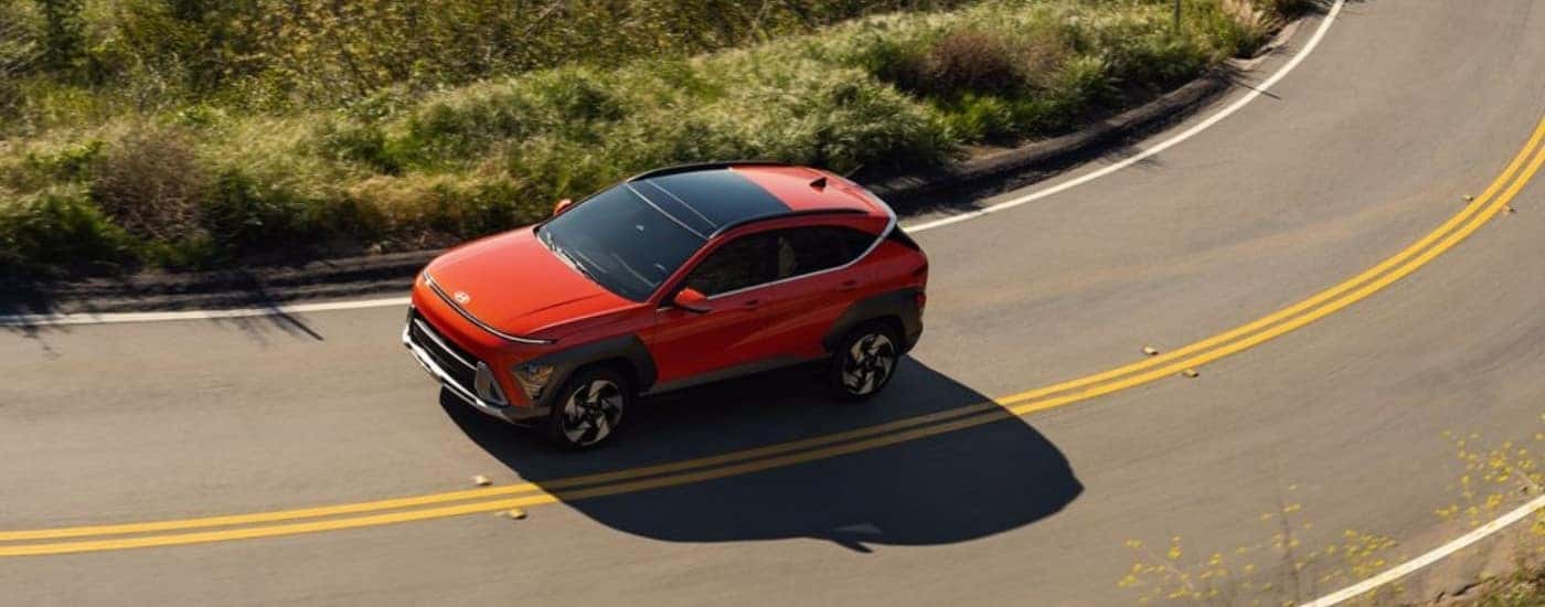 An orange 2025 Hyundai Kona from a high angle.