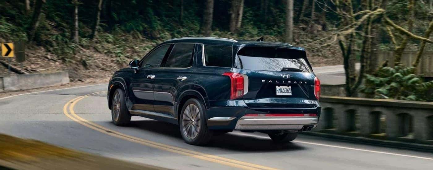A dark blue 2023 Hyundai Palisade driving down a highway