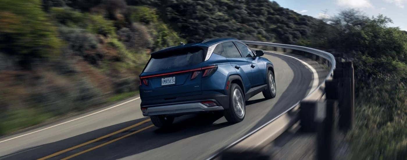 A blue 2025 Hyundai Tucson from the rear at an angle.