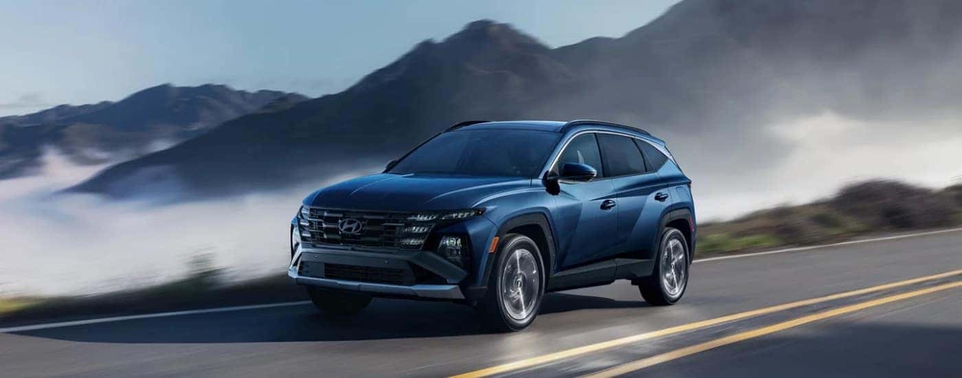 A blue 2025 Hyundai Tucson from the front at an angle.