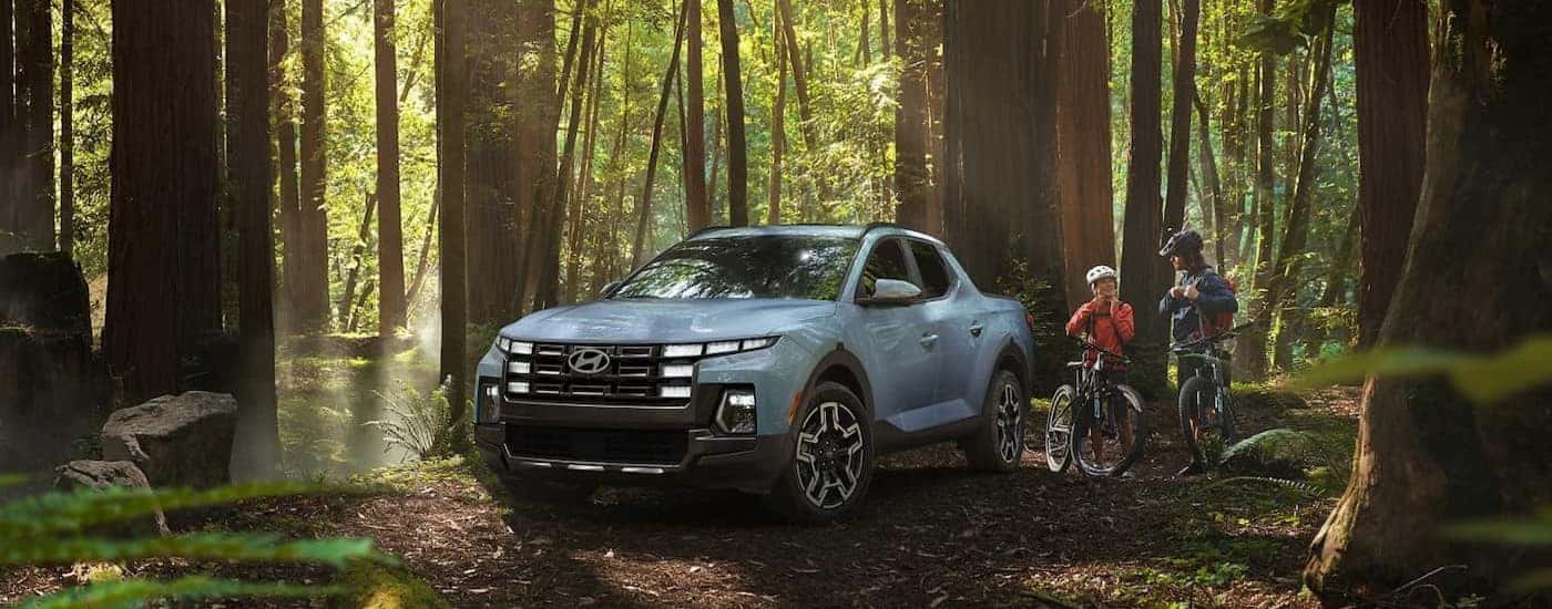 A blue 2025 Hyundai Santa Cruz parked in a forest.