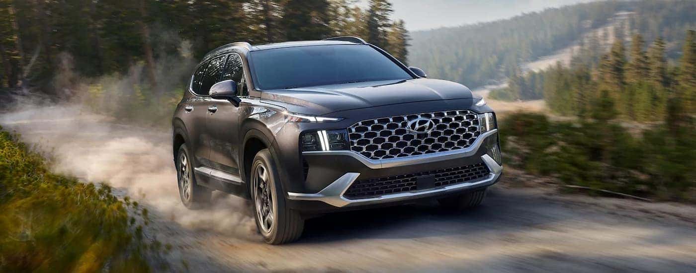 A used black 2022 Hyundai Santa Fe driving down a trail.