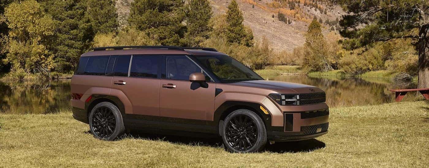 A copper 2026 Hyundai Santa Fe parked near a pond.