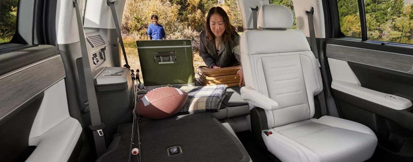 Woman grabbing camping gear from the back of a 2025 Hyundai Santa Fe