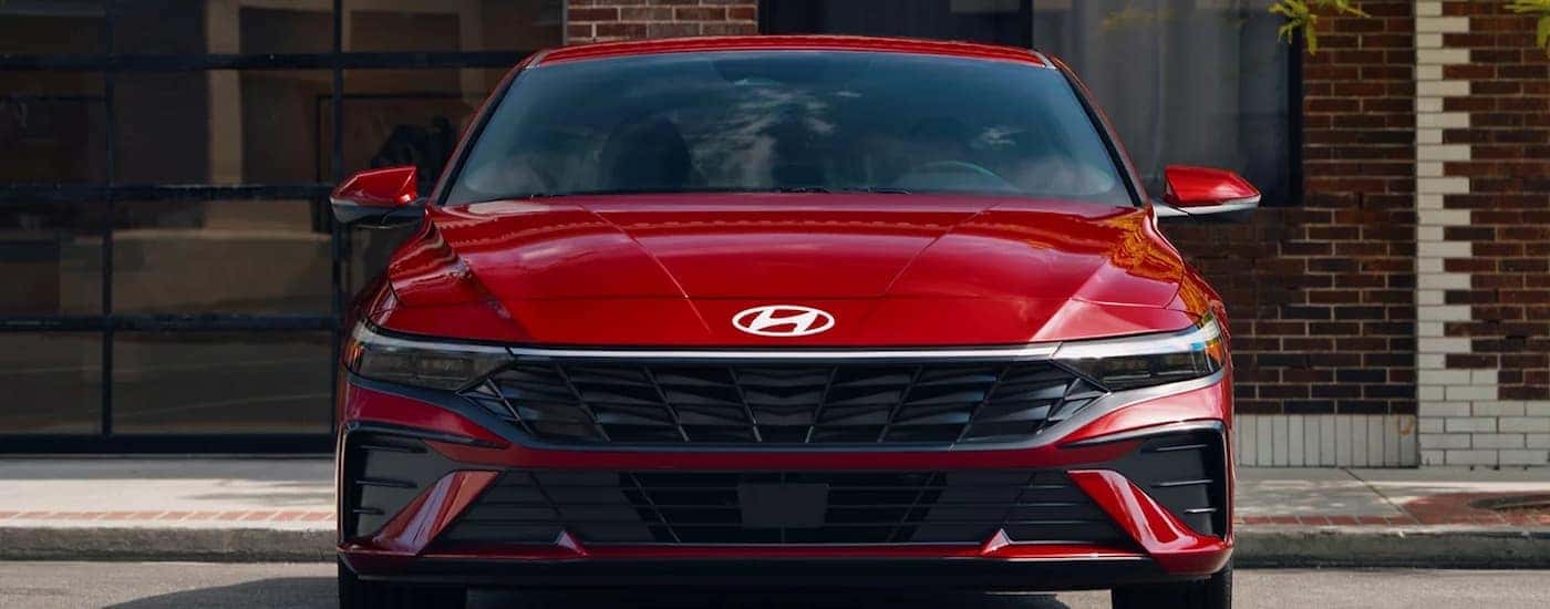 A red 2025 Hyundai Elantra parked outside a building