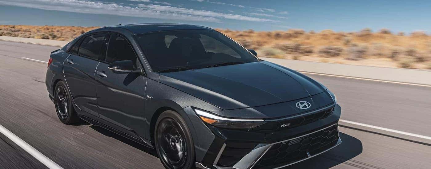 A gray 2025 Hyundai Elantra driving down a highway