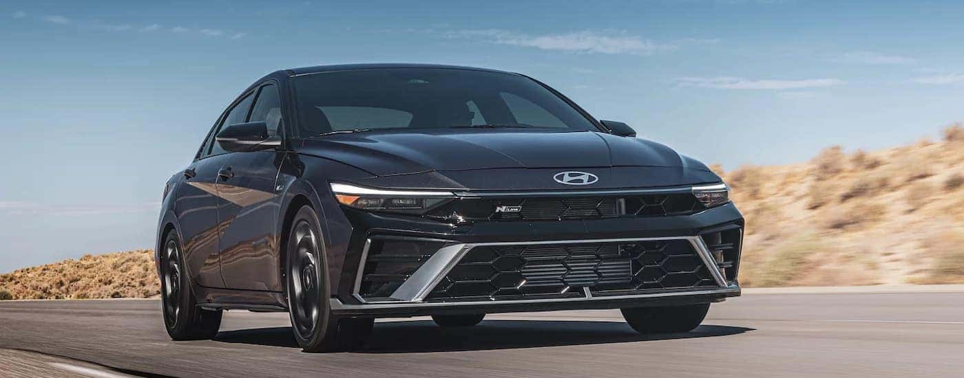 A dark gray 2025 Hyundai Elantra driving down a highway