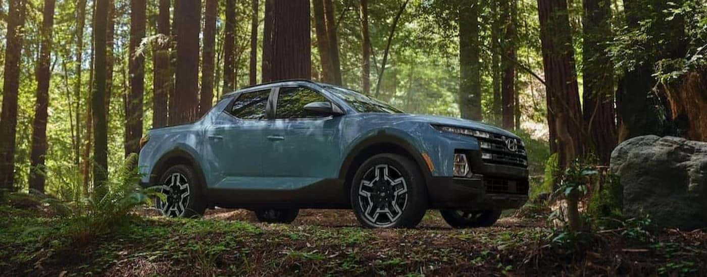 A blue 2024 Hyundai Santa Cruz parked off-road.