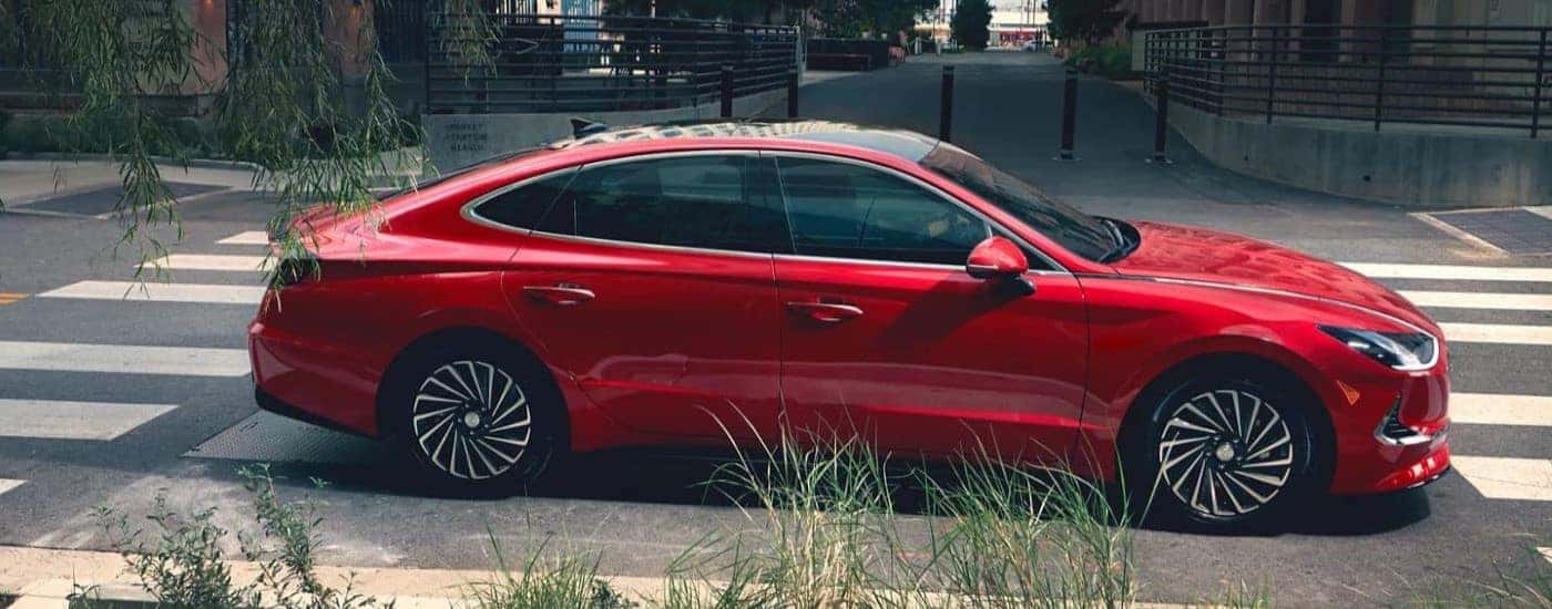 A red 2021 Hyundai Sonata Hybrid parked on a city street