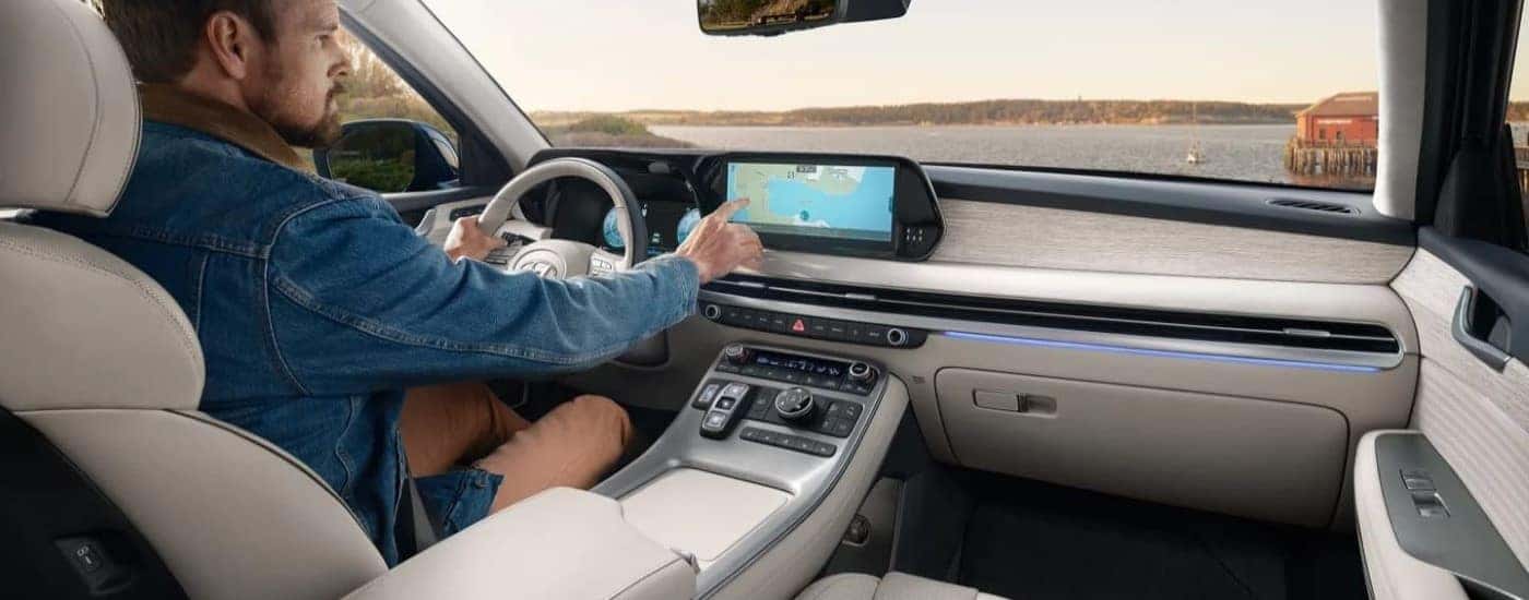 A man using the infotainment touch screen in a 2023 Hyundai Palisade for sale near Huntsville