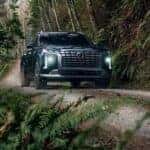 Green 2023 Hyundai Palisade driving up a trail