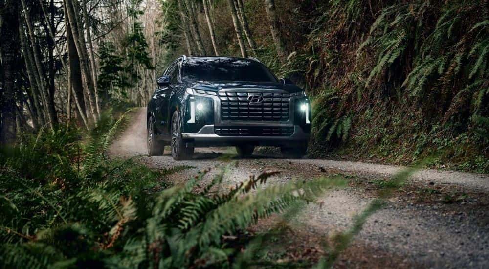 Green 2023 Hyundai Palisade driving up a trail