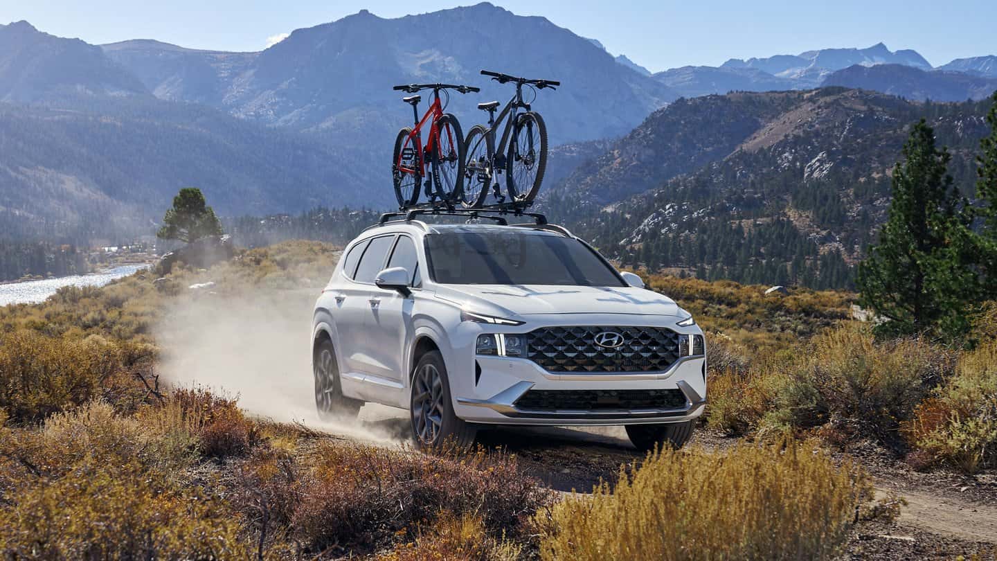 A white 2021 Hyundai Santa Fe driving on a dirt path.