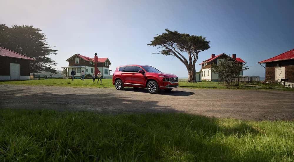 A red 2023 used Hyundai Santa Fe for sale parked on a driveway.