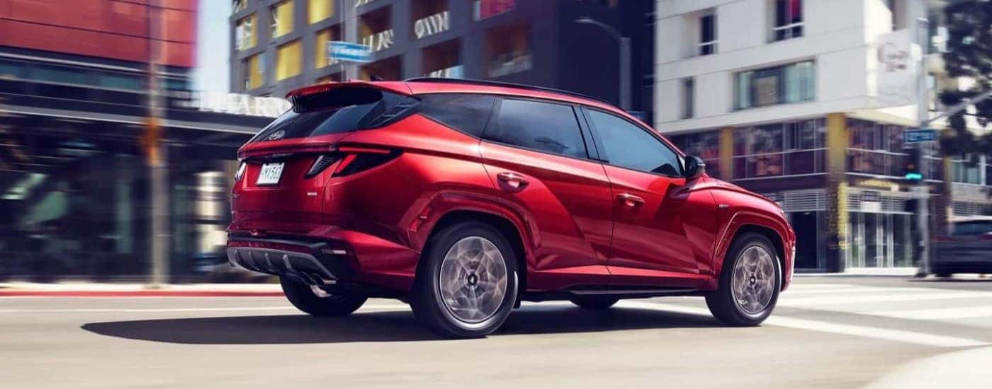 A red 2023 Hyundai Tucson N-Line driving in a city