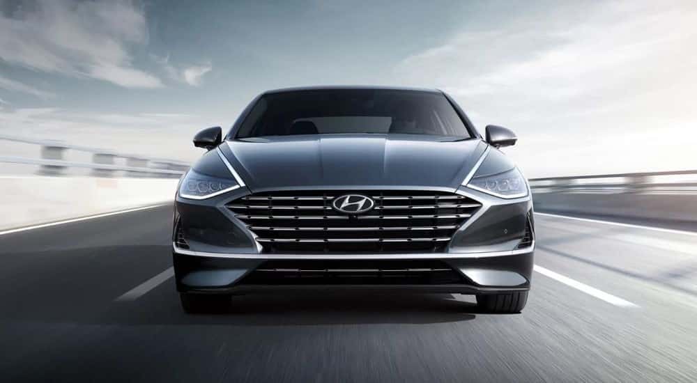 Gray 2021 Hyundai Sonata Hybrid shown driving from the front.