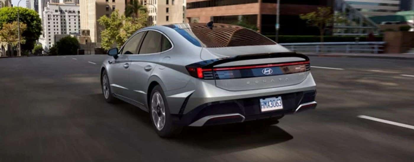 A silver 2026 Hyundai Sonata Hybrid Limited shown driving from rear.