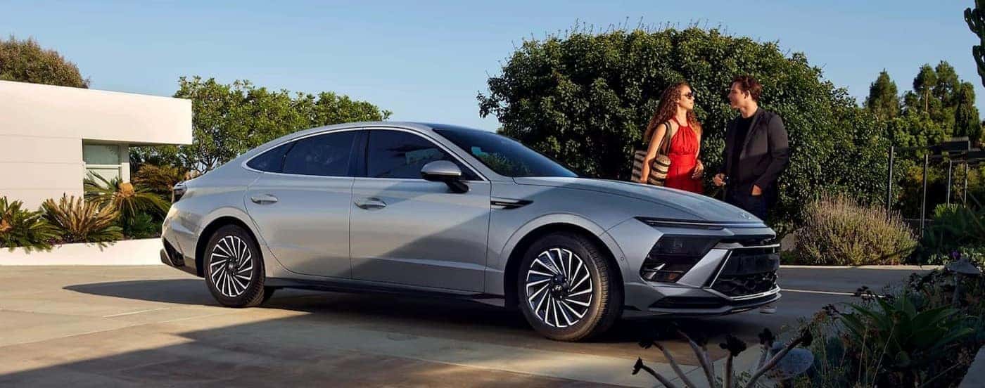 Two people standing near a silver 2026 Hyundai Sonata.