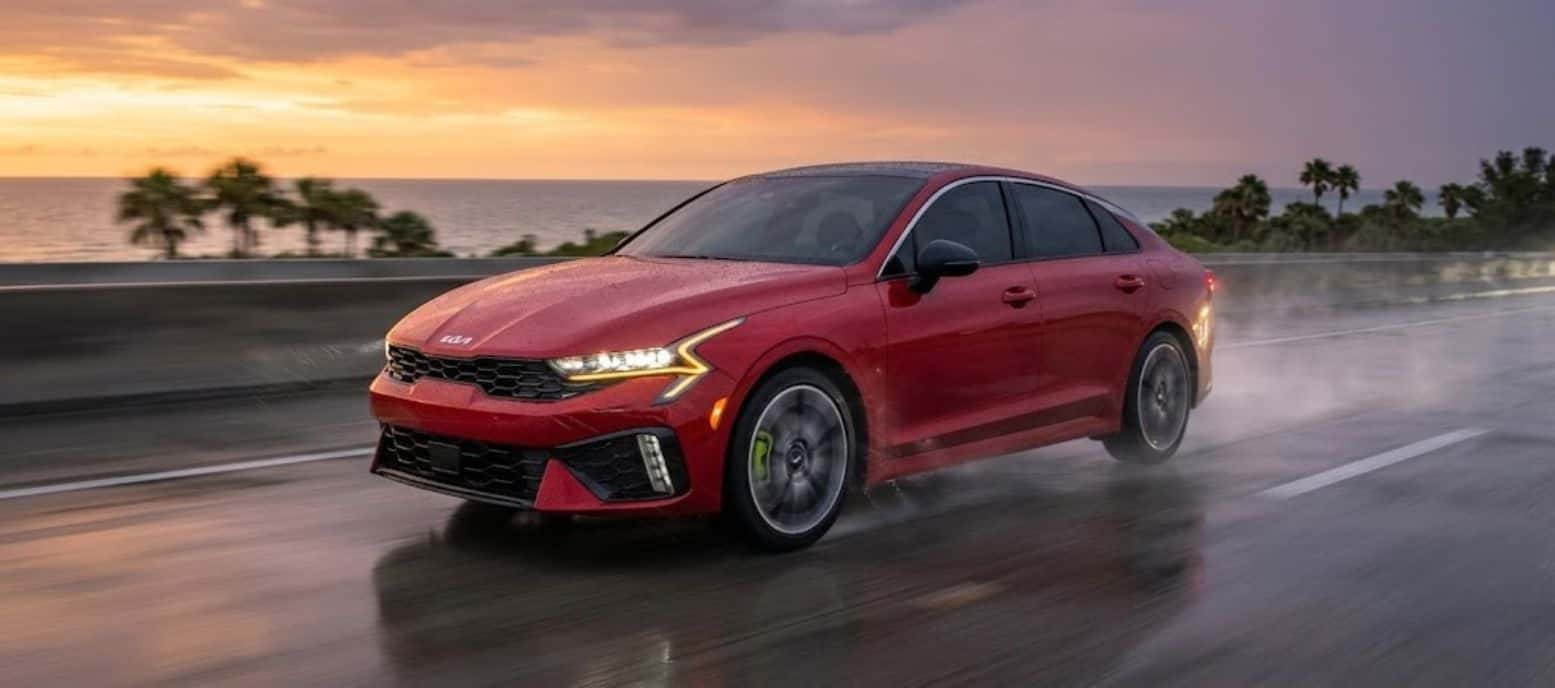 2026 Kia K5 performing on a wet Florida road at dusk