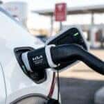 Close-up of a Kia NACS-to-CCS adapter connecting a Tesla Supercharger cable to a Kia EV6 charging port.