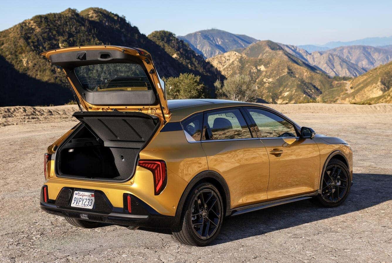 The rear hatch of the yellow 2026 Kia K4 Hatchback open to display the cargo loading floor