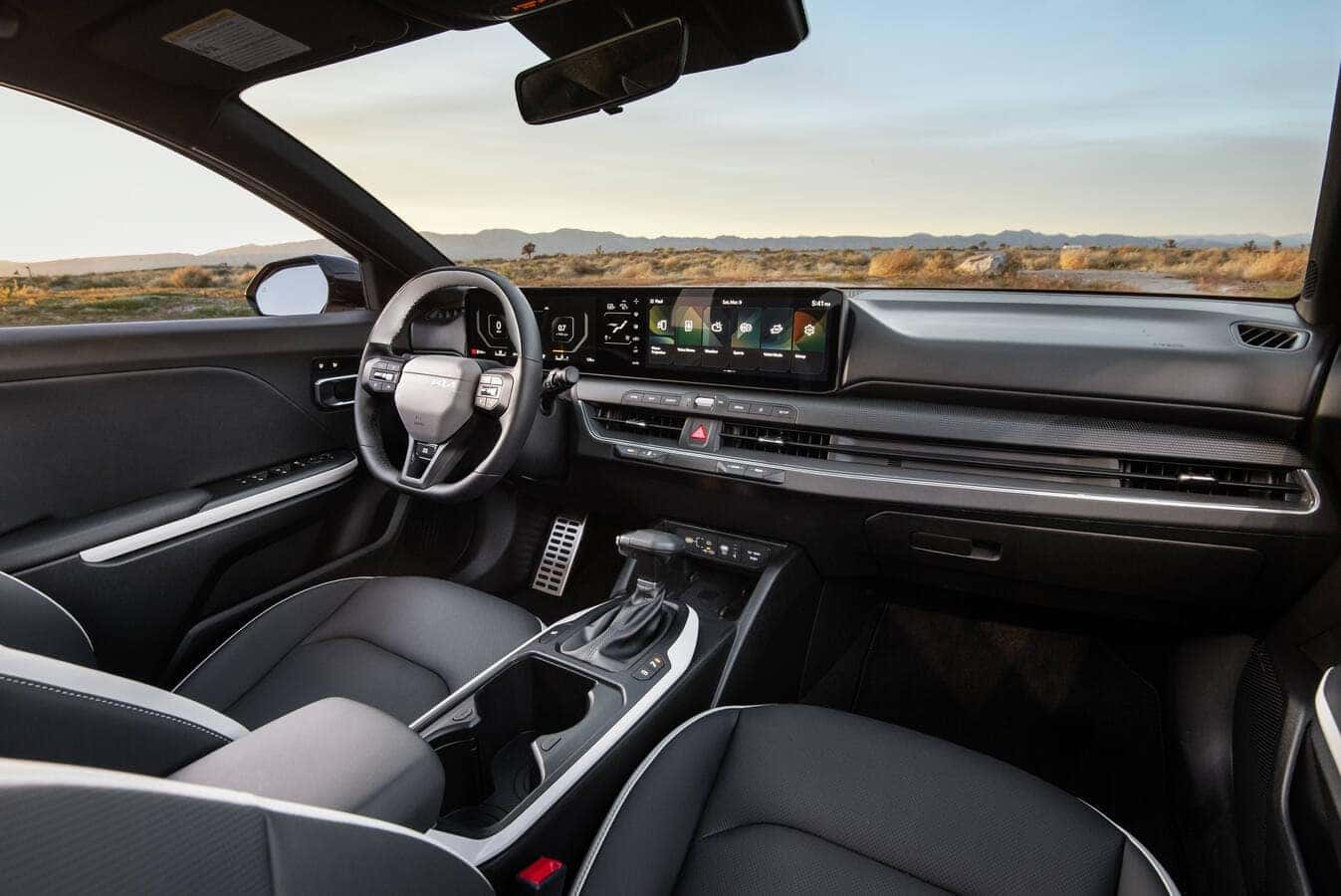 The high-tech driver cabin of the 2026 Kia K4 highlighting the sweeping panoramic dashboard display