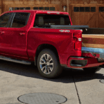 2020 chevrolet silverado 1500 red exterior with couple putting plans of wood into bed of truck
