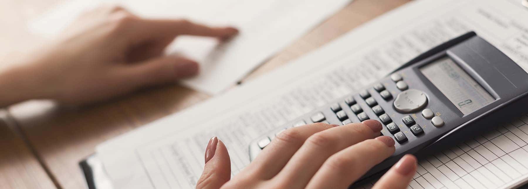 defining APR at Jim Coleman Auto Group in Maryland | Woman calculating finances