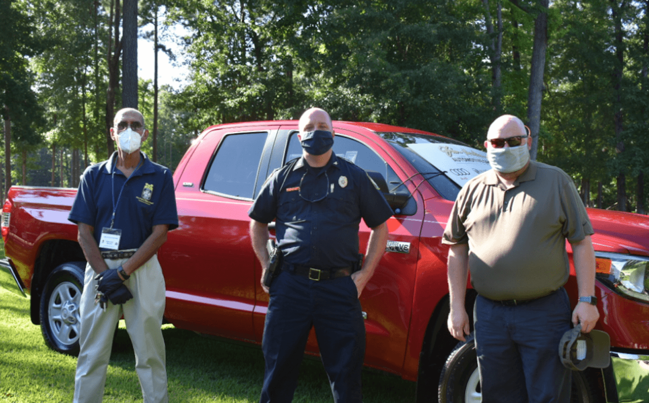 Jim Hudson and police officers in front of truck