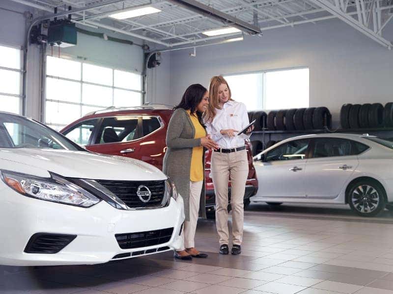 Nissan Service Center A service technician and a woman going over repairs