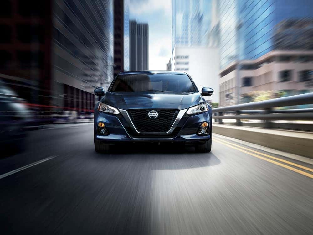 2020 Nissan Altima A blue 2020 Nissan Altima driving through a city
