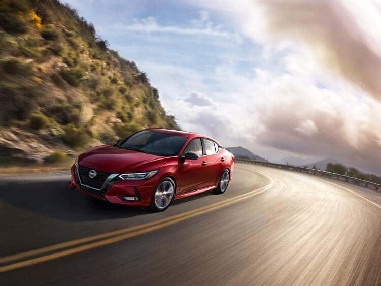 2020 Nissan Sentra A red 2020 Nissan Sentra driving around a highway bend