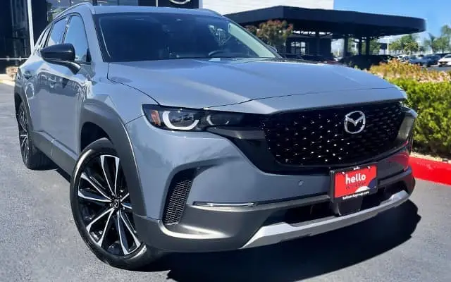 A red Mazda sedan is turning city corner