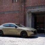2025 Mzada3 hatchbacksitting outside of a garage.