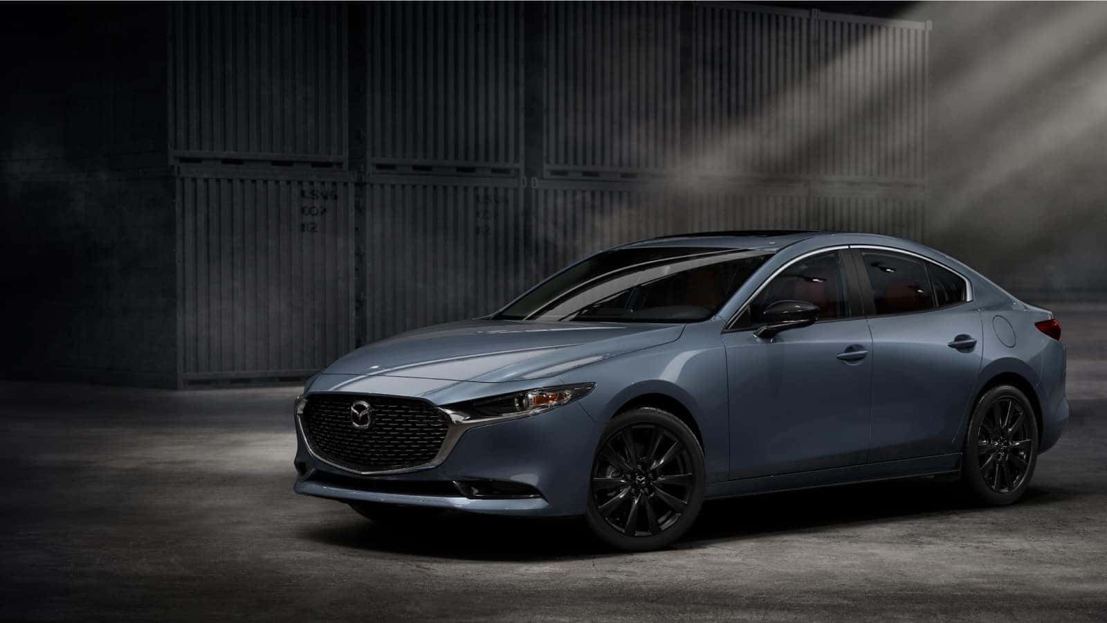 2025 Mazda 3 carbon driving down road.