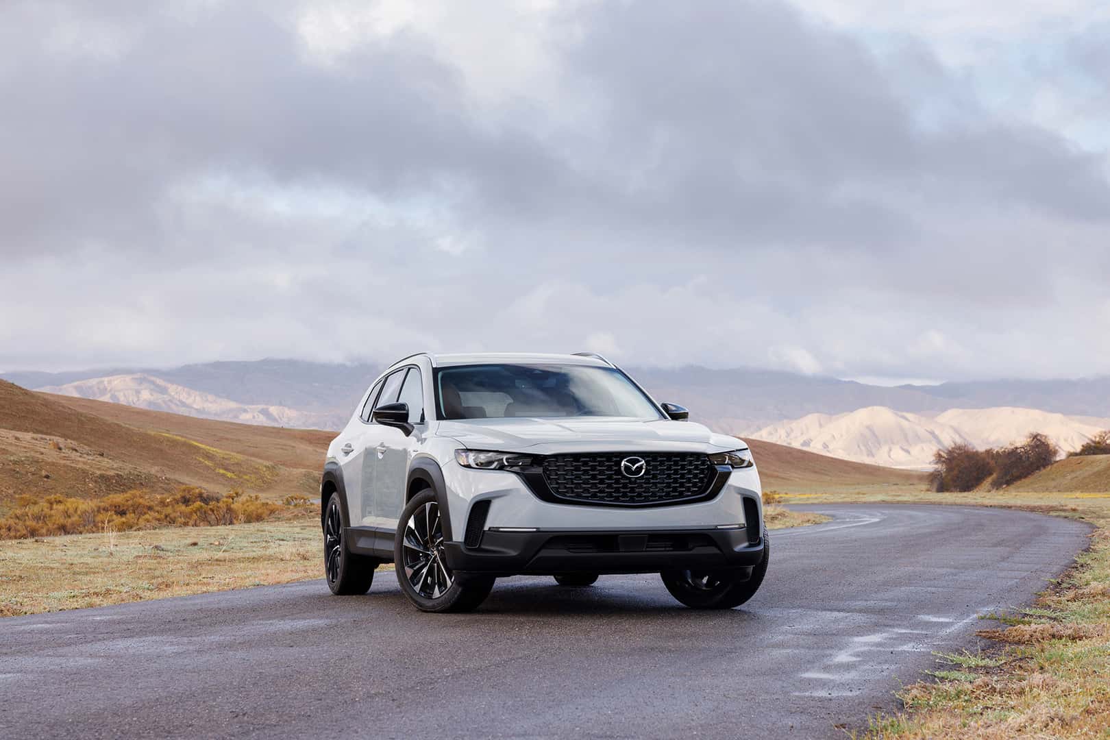 White Mazda cx-50 parked with desert in the background