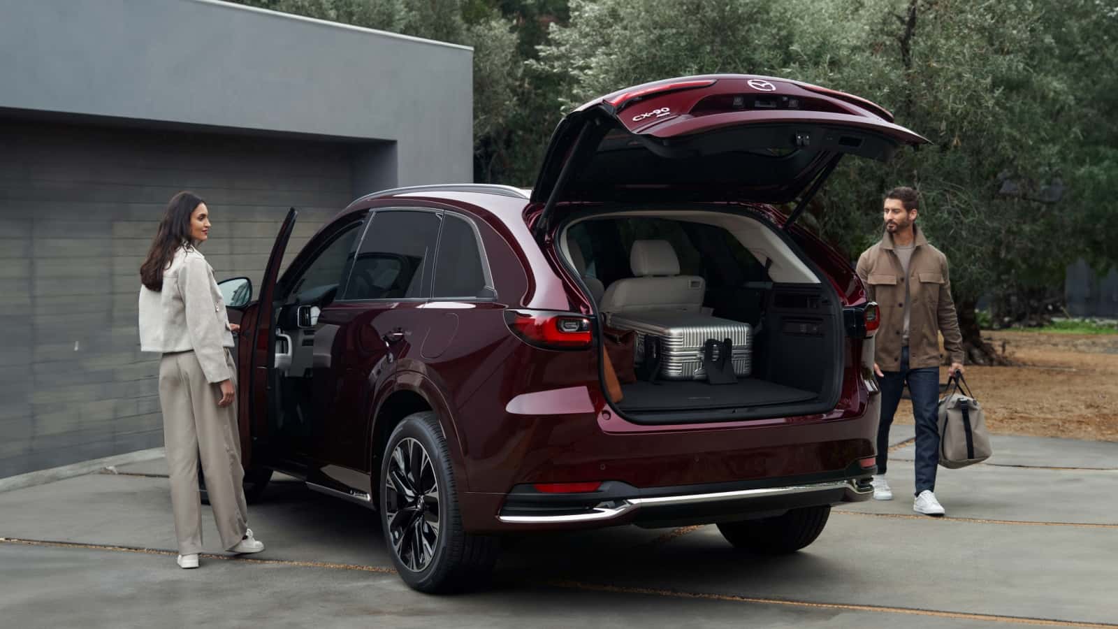 a Red 2025 Mazda CX-90 with the hatch opened up parked in a driveway.