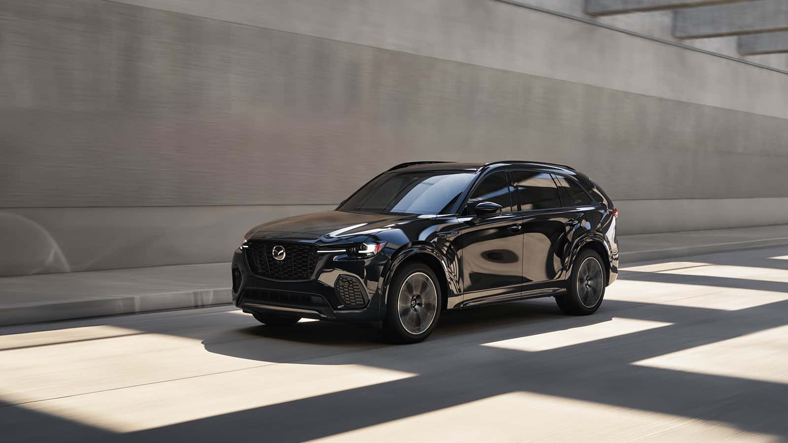 A black Mazda CX-70 driving down the highway.