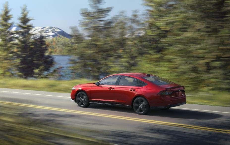New Honda Accord Hybrid in red driving down highway