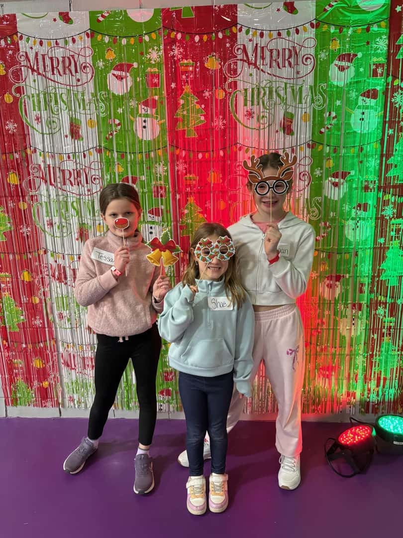 3 children in front of christmas backdrop