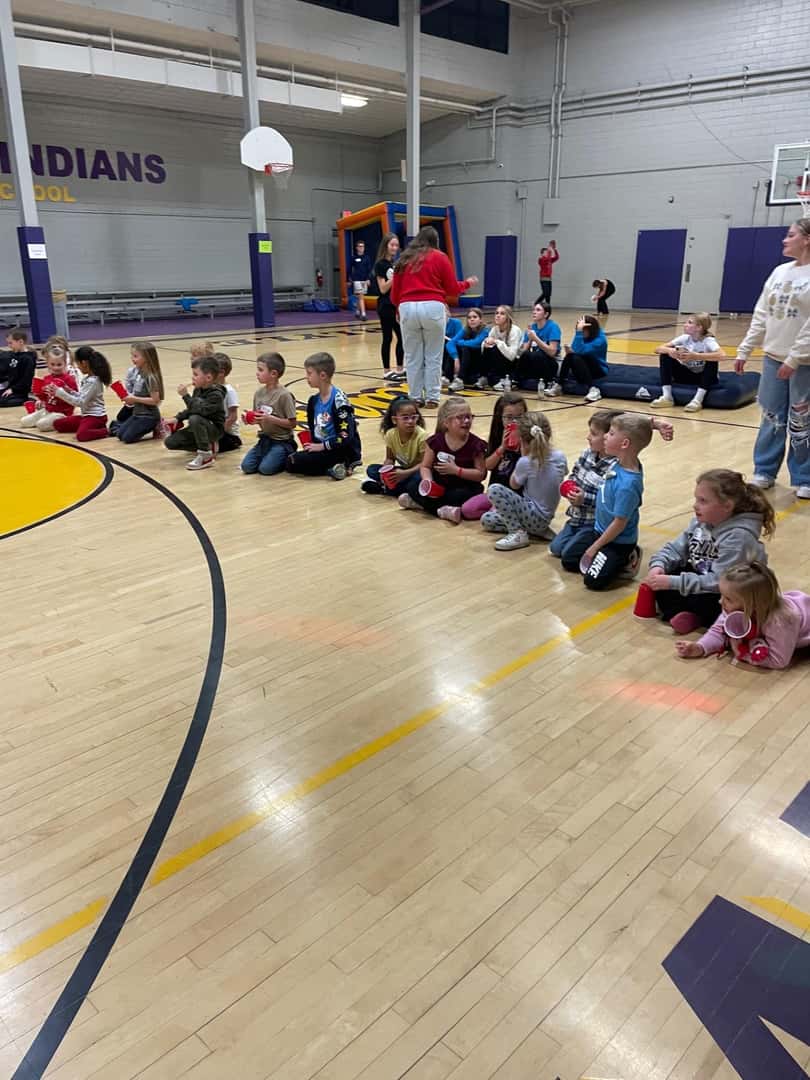 group of children sitting on gym floor