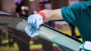 A windshield being repaired by a technician