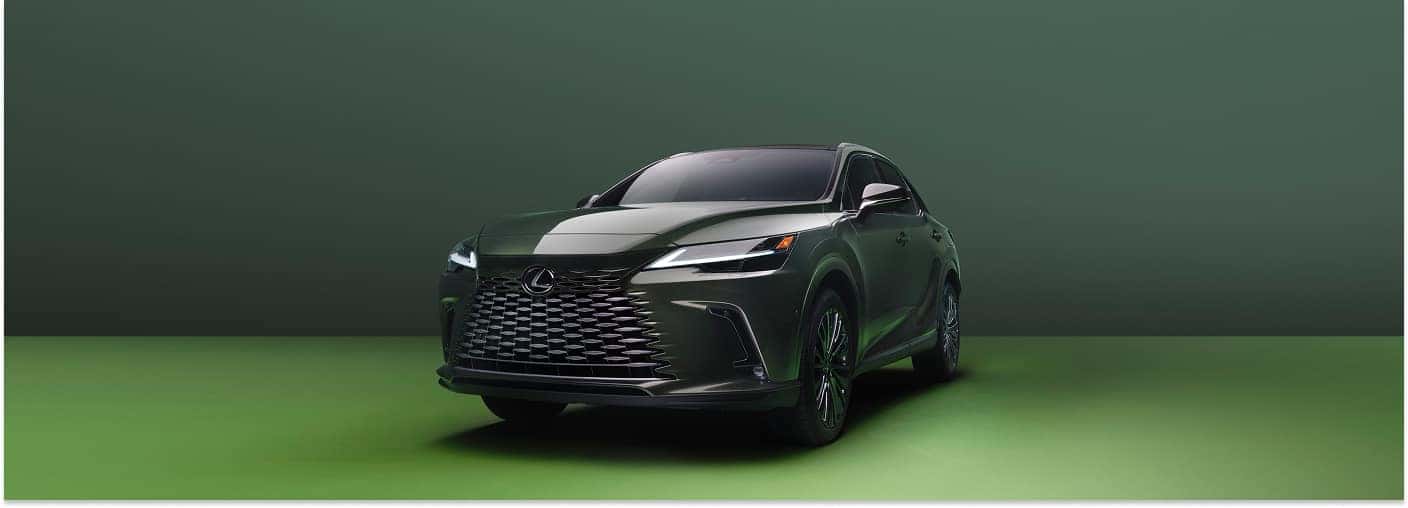 Front three-quarter view of a dark green 2026 Lexus RX SUV parked in a green studio setting.