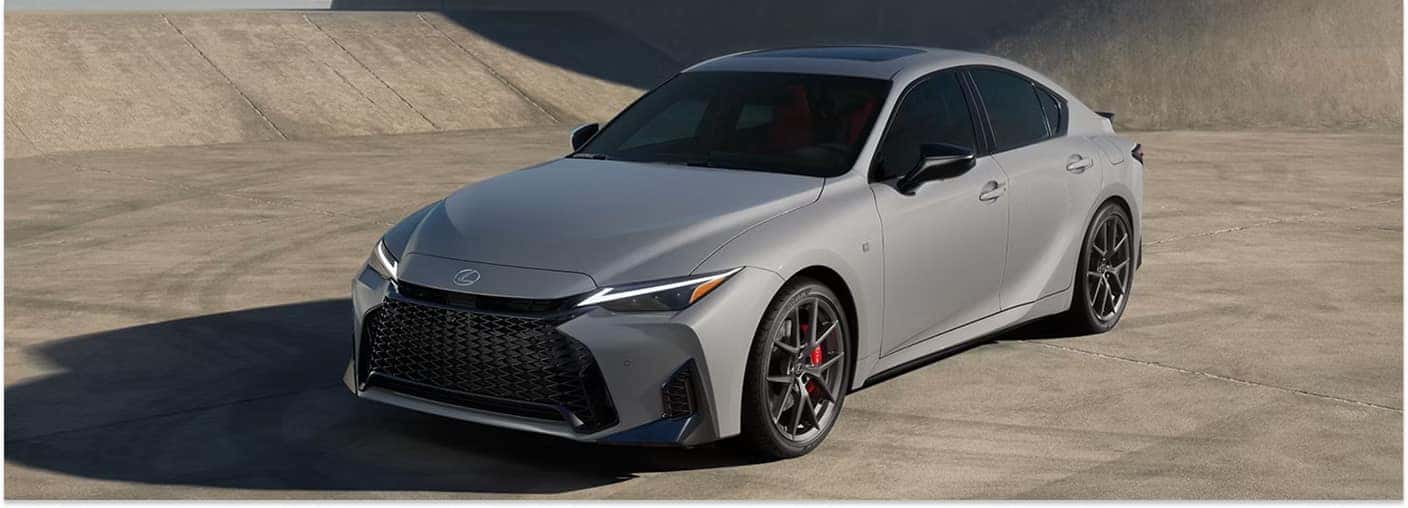 Front three-quarter view of a grey 2026 Lexus IS sedan parked on a concrete surface.