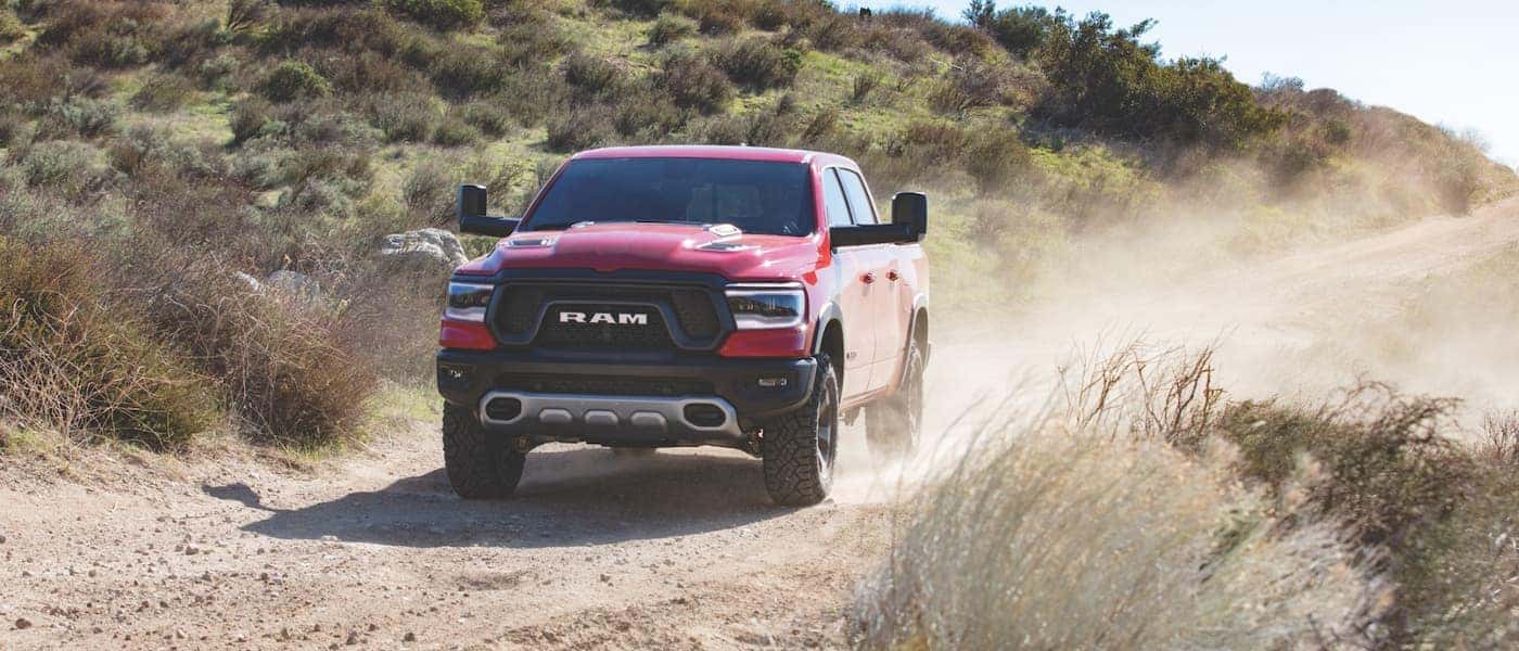 Ram 1500 A red Ram 1500 driving down a dirt road
