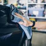 A man cleaning car with microfiber cloth