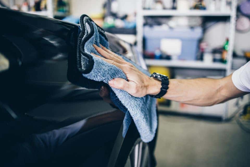 A man cleaning car with microfiber cloth